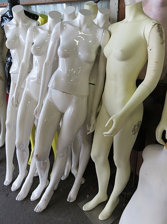 Row of white female mannequins in a storage room