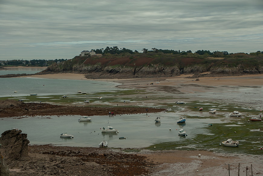 Coastal landscape at low tide with boats in shallow water