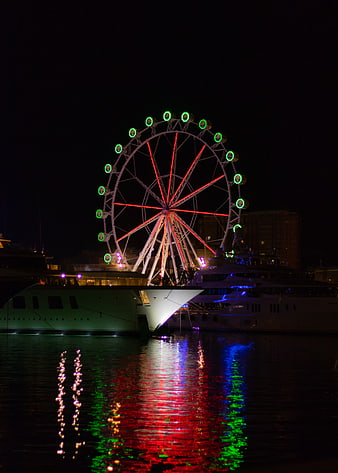 Illuminated Ferris Wheel and Yachts at Night