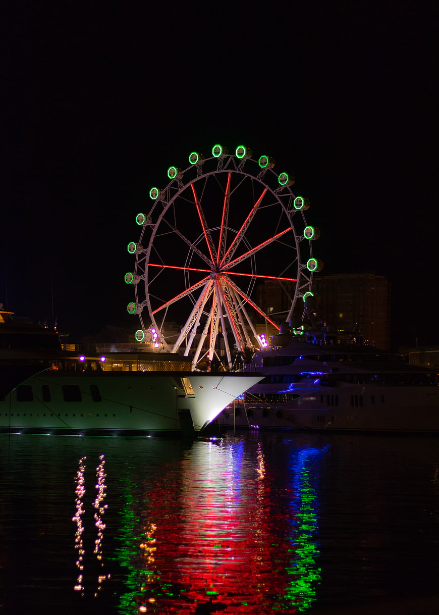 Illuminated Ferris Wheel and Yachts at Night