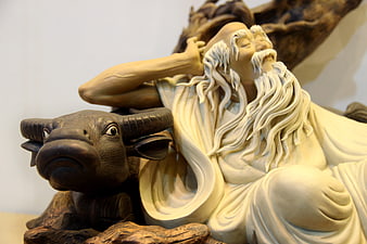Detailed sculpture of elderly bearded man resting with ox