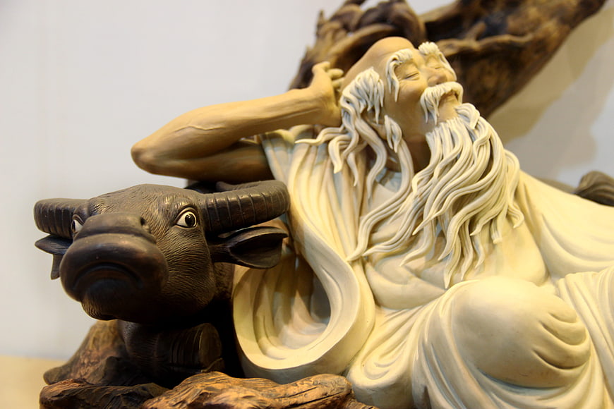 Detailed sculpture of elderly bearded man resting with ox