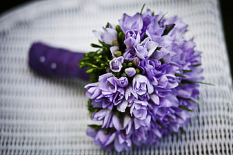 Close-up of purple bridal bouquet on white textured background
