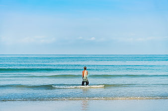 Man Standing in Ocean Waves Looking at Horizon