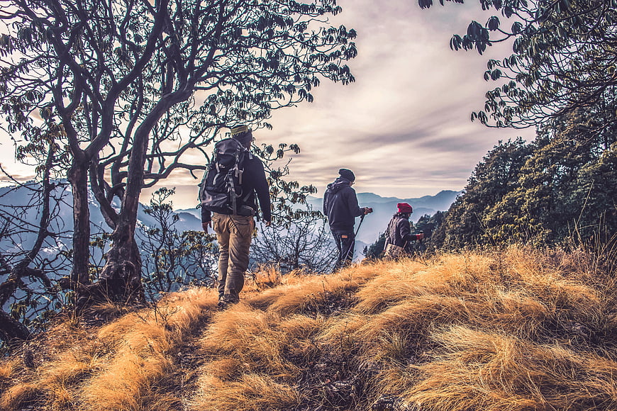 Hikers walking on mountain trail with scenic view