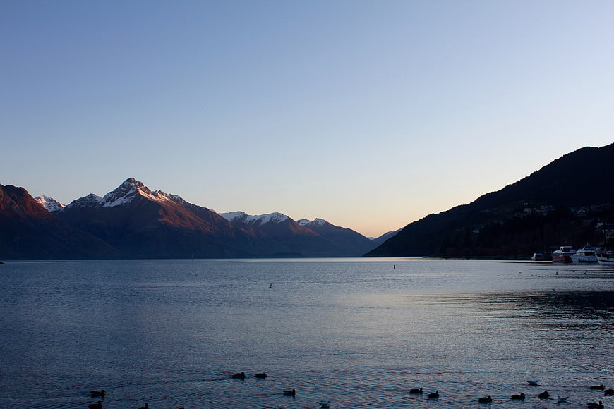 Serene Lake Landscape with Snow-Capped Mountains at Sunset