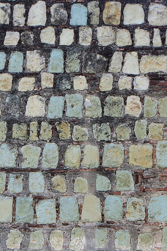 Textured wall with weathered bluish and beige stones