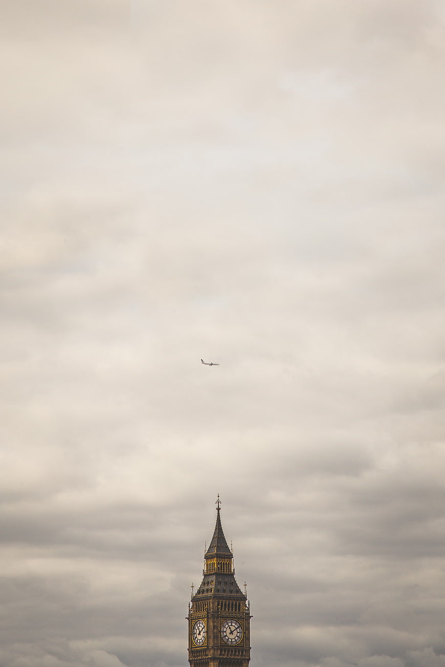 Big Ben Clock Tower with Airplane in Cloudy Sky