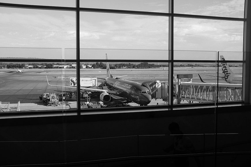 Black and White Airport Terminal View with Airplane