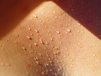 Close-up of sweat droplets on human skin with dramatic lighting