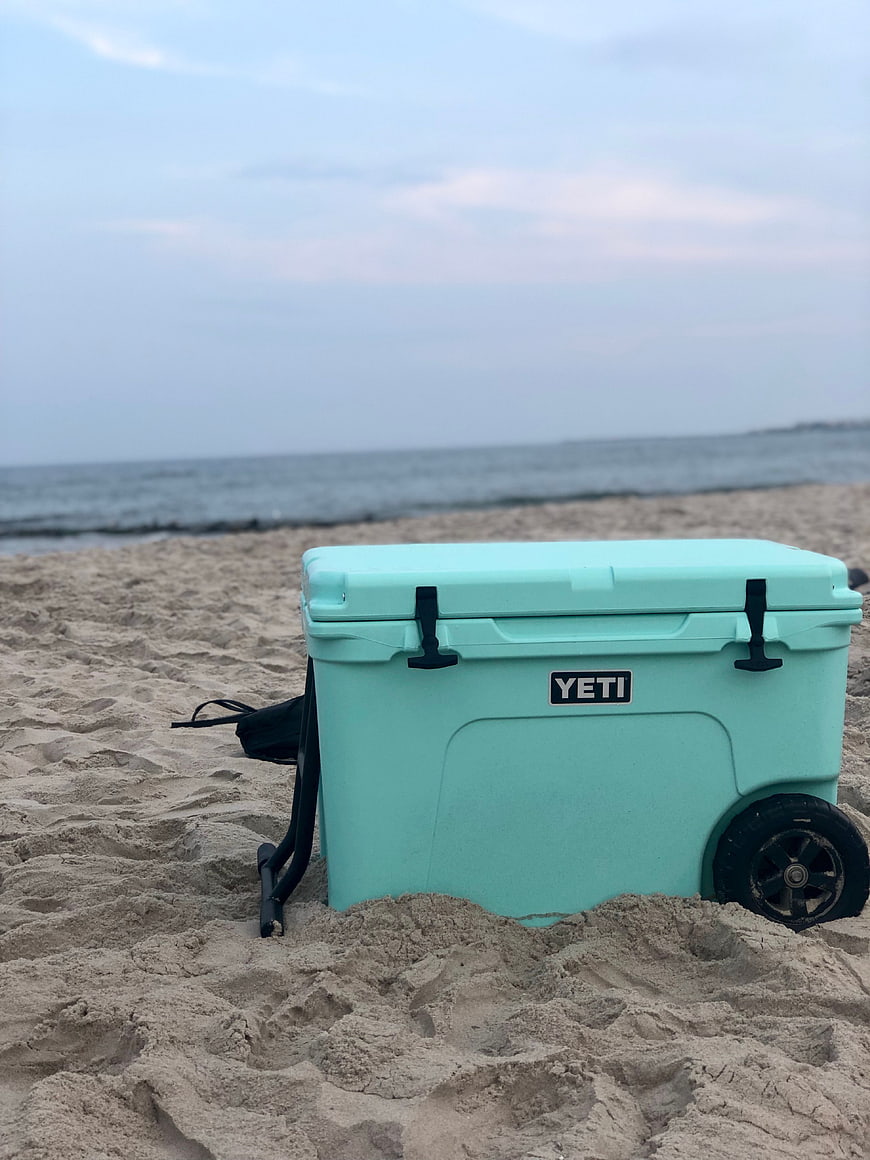 Teal Yeti Cooler on Sandy Beach with Ocean Background