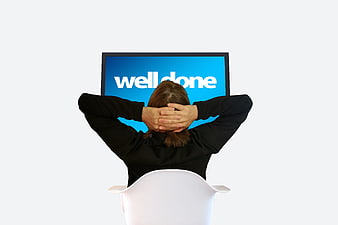 Woman relaxing at computer with well done message on screen