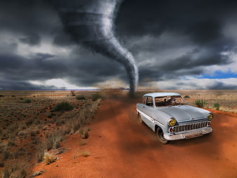 Vintage car driving away from tornado in desert landscape