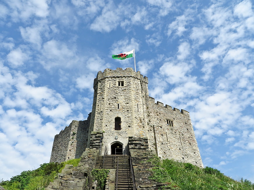 Cardiff Castle Tower With Welsh Flag Against Blue Sky