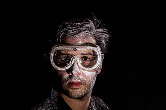 Portrait of man with safety goggles covered in white powder