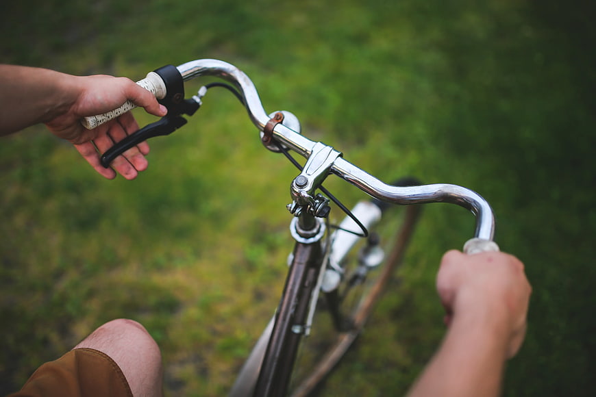 First-person view of hands on bicycle handlebars