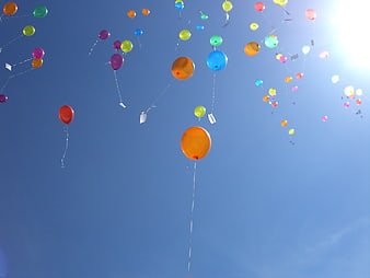Colorful Balloons Floating In Blue Sky With Sunlight