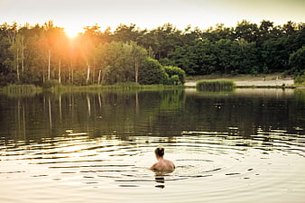 Woman Swimming in Lake at Golden Hour Sunset