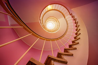 Low angle view of pink spiral staircase with wooden steps