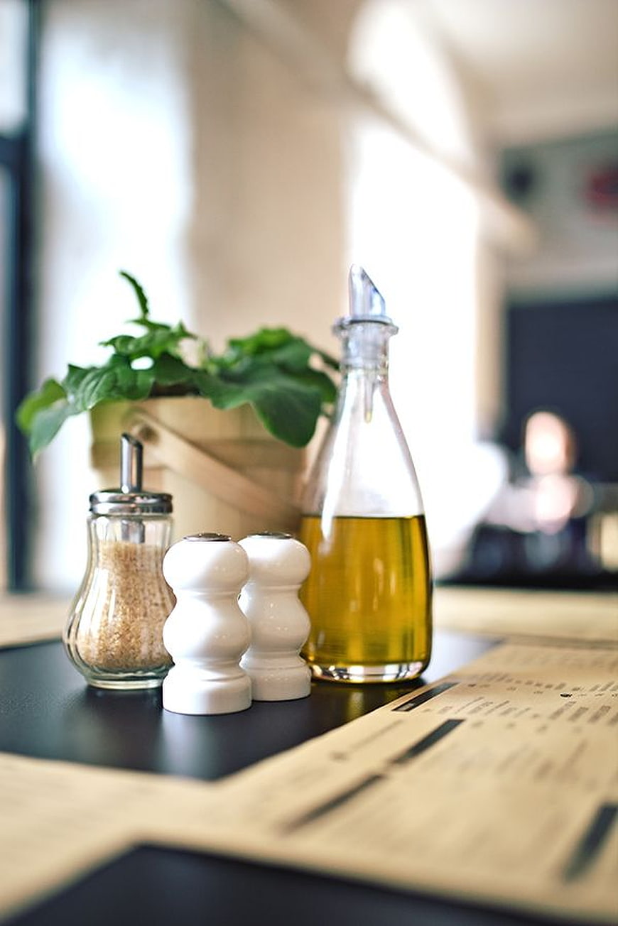 Restaurant table setting with olive oil, salt, and pepper