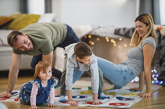 Happy family playing Twister game on living room floor