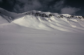 Dramatic Snow-Covered Mountain Landscape with Dark Clouds
