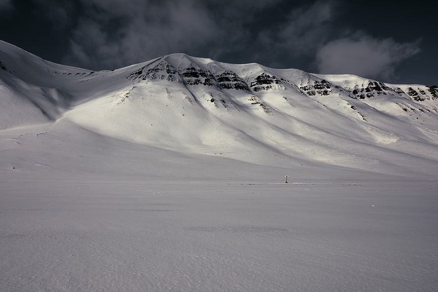 Dramatic Snow-Covered Mountain Landscape with Dark Clouds