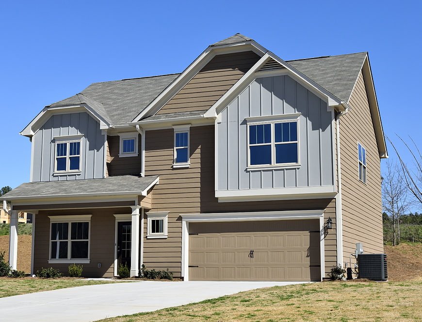 Modern two-story suburban house exterior with attached garage and brown siding