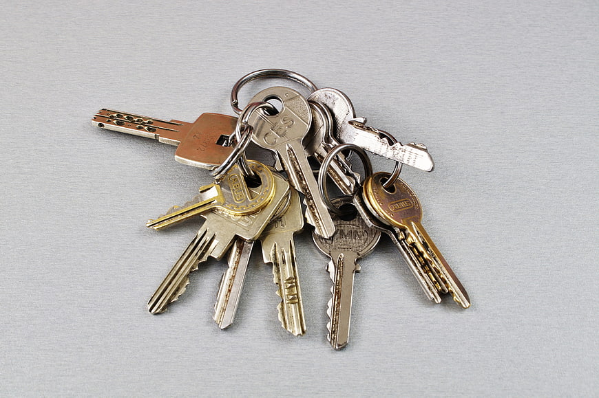 Assorted metal keys on a ring against a gray background