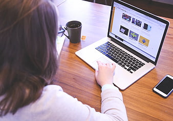 Woman Using Laptop on Wooden Desk with Coffee