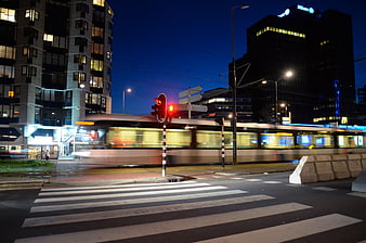 Motion blur tram crossing zebra crossing in Rotterdam at night