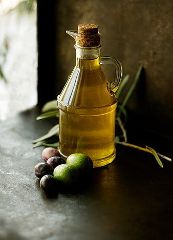 Glass Bottle of Olive Oil with Fresh Olives and Branches