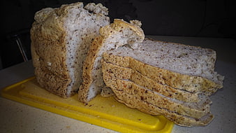 Sliced gluten-free bread loaf on yellow cutting board