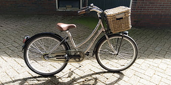 Silver Vintage Bicycle with Wicker Basket on Paved Path
