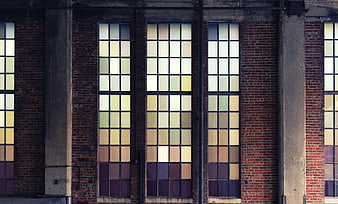 Colorful stained glass windows on industrial brick building facade