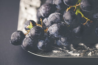 Close-up of dark purple grapes on a silver platter