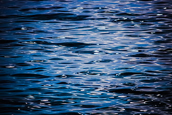 Deep blue water ripples with shimmering light reflections