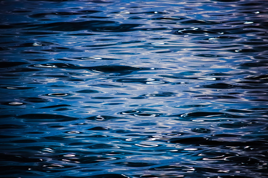 Deep blue water ripples with shimmering light reflections