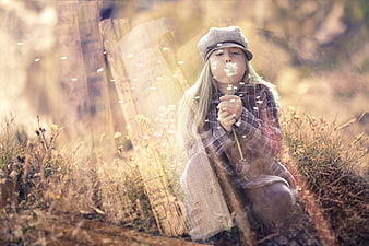 Girl Blowing Dandelion Seeds in Dreamy Autumn Field
