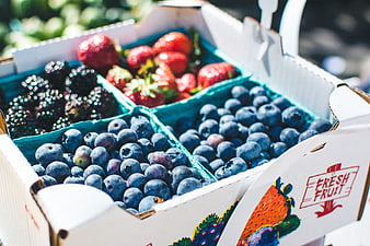 Fresh mixed berries in a cardboard box at a market