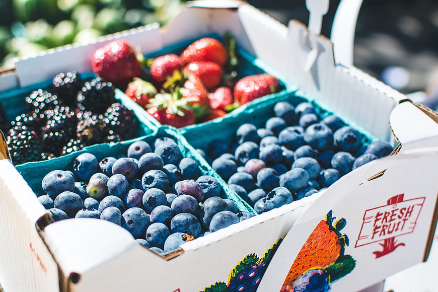 Fresh mixed berries in a cardboard box at a market