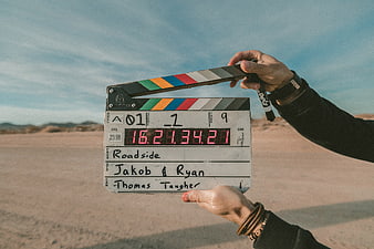 Film clapperboard held in desert landscape