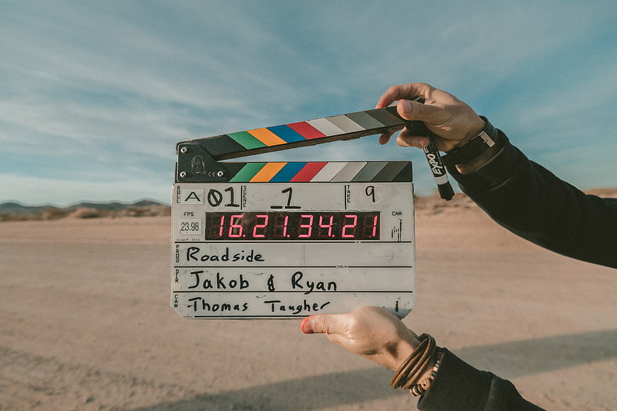 Film clapperboard held in desert landscape