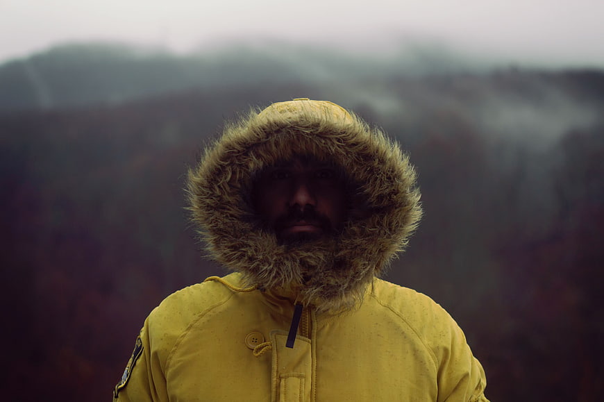 Man in Yellow Fur Hooded Jacket in Foggy Forest