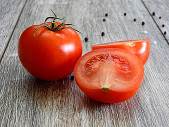 Fresh Red Tomatoes With Slices On Rustic Weathered Wooden Table