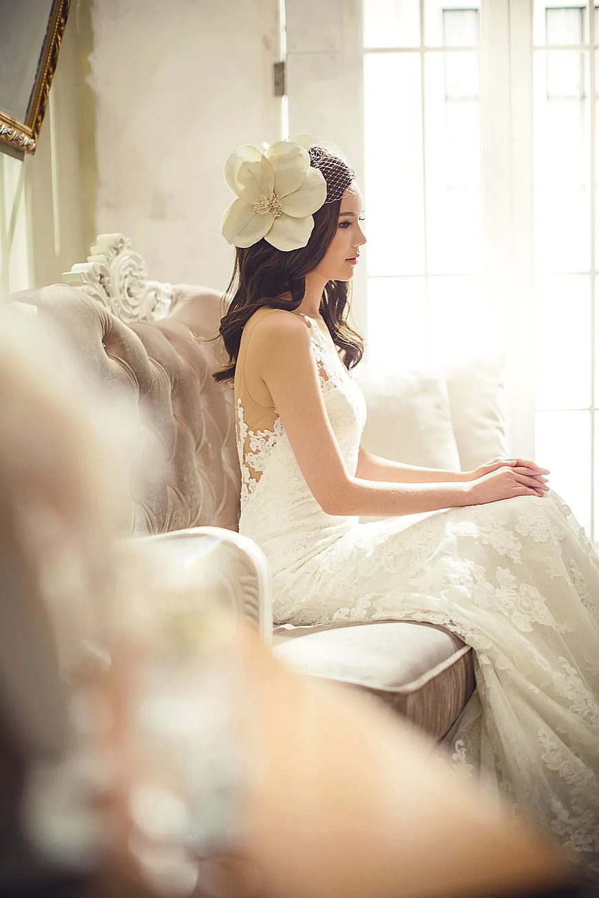 Bride in Lace Wedding Dress Sitting by Window