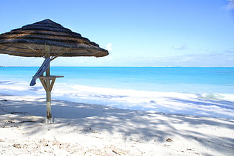 Thatched Beach Umbrella On White Sand With Turquoise Ocean Water