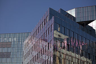Modern glass office building facade with blue sky