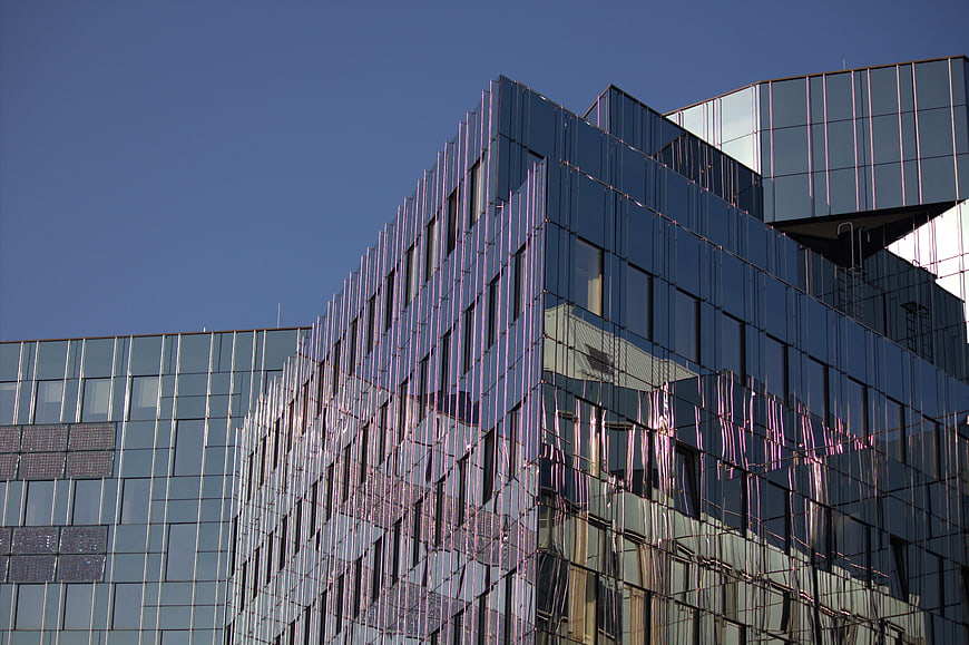 Modern glass office building facade with blue sky