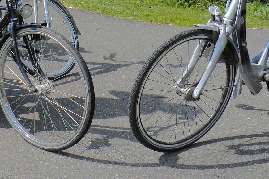 Close-up of bicycle wheels on asphalt path